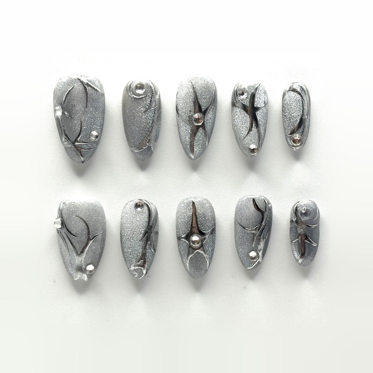 Liquid Silver press-on nails: holographic silver almonds with raised mirror line work, four-point stars and clear crystals