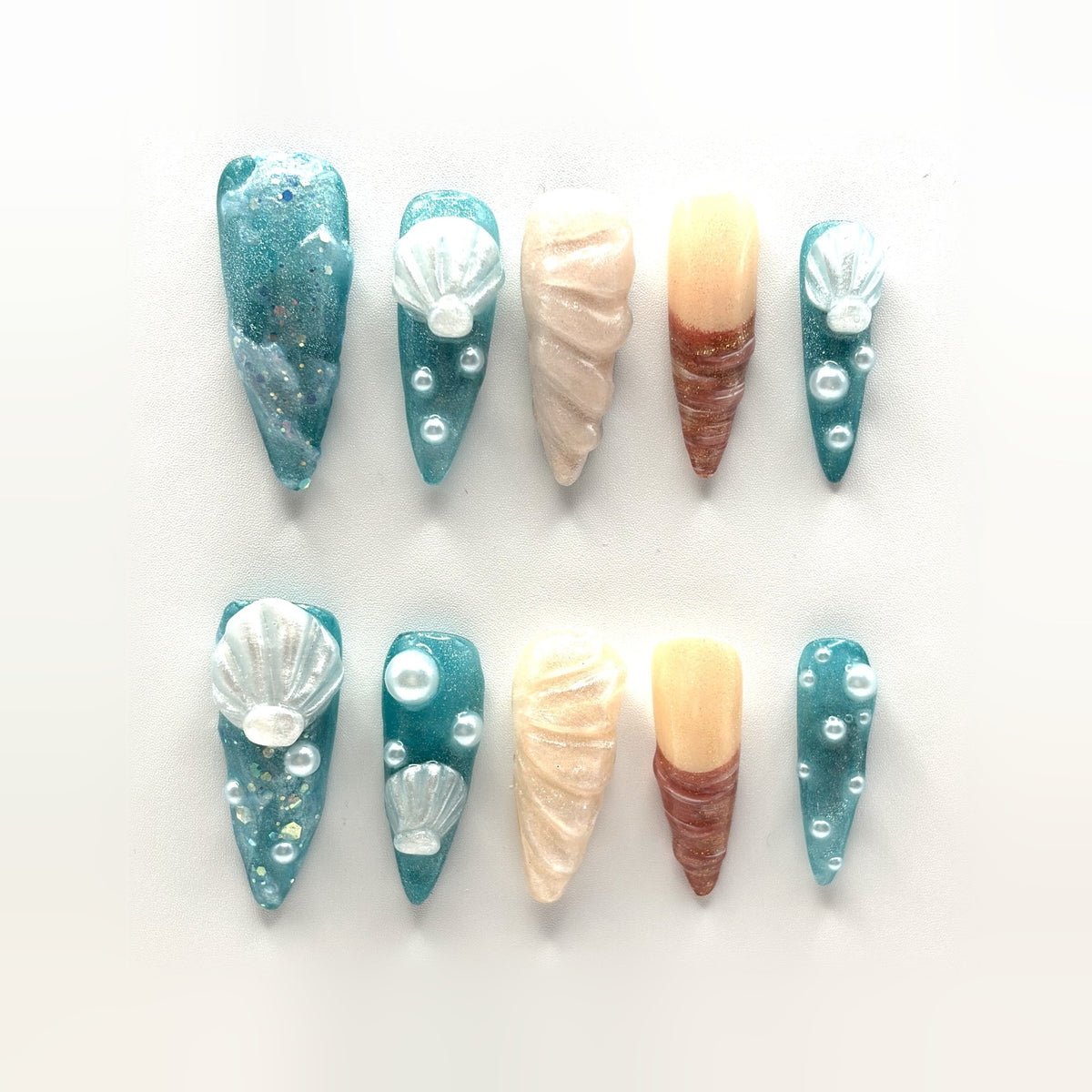 Siren Shell press-on nails: long teal jelly stilettos with sculpted shells, pearl beads, gold flake and two conch nails