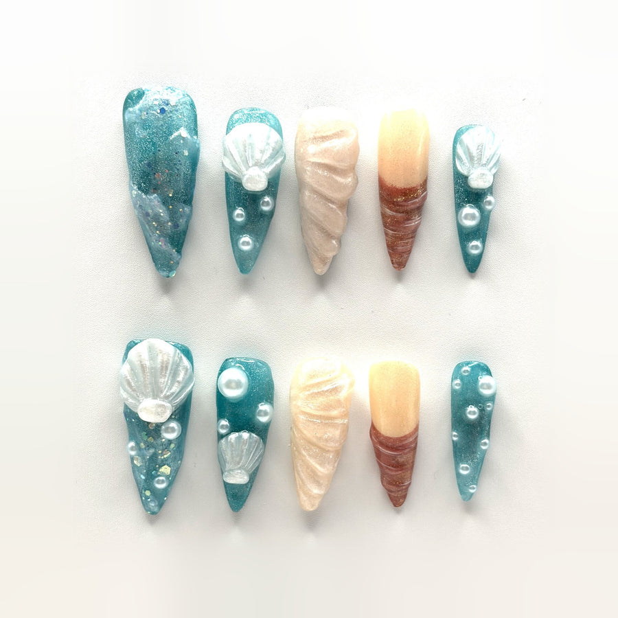 Siren Shell press-on nails: long teal jelly stilettos with sculpted shells, pearl beads, gold flake and two conch nails