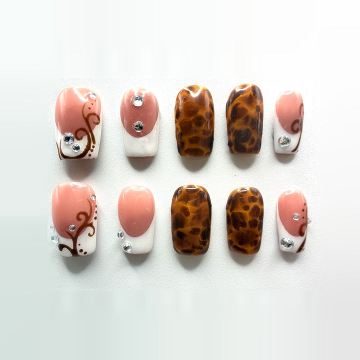 Tuscan French press-on nails: ten short square nails, rosy pink and white French tips with amber tortoiseshell accents, brown vine swirls and rhinestones